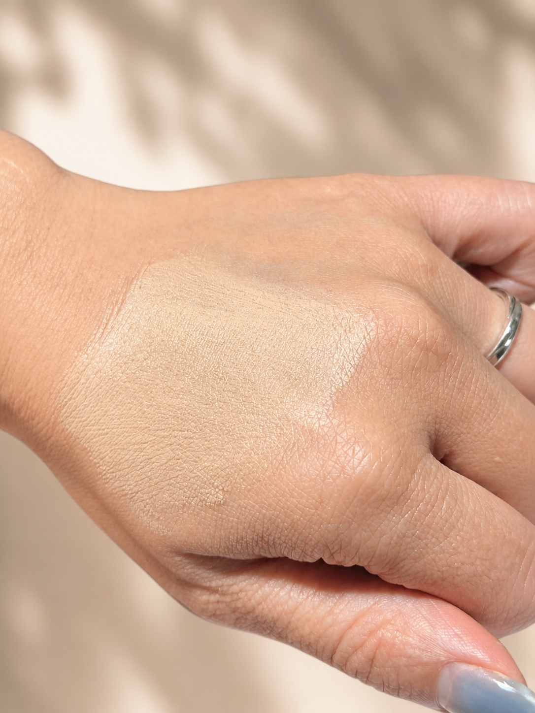 A sheer swatch of Beauty of Joseon Daily Tinted Fluid Sunscreen on the back of a hand