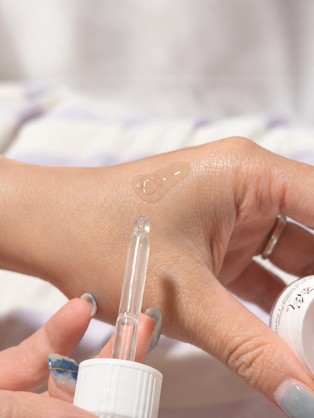A dropper dispensing the Beauty of Joseon serum onto the back of a hand