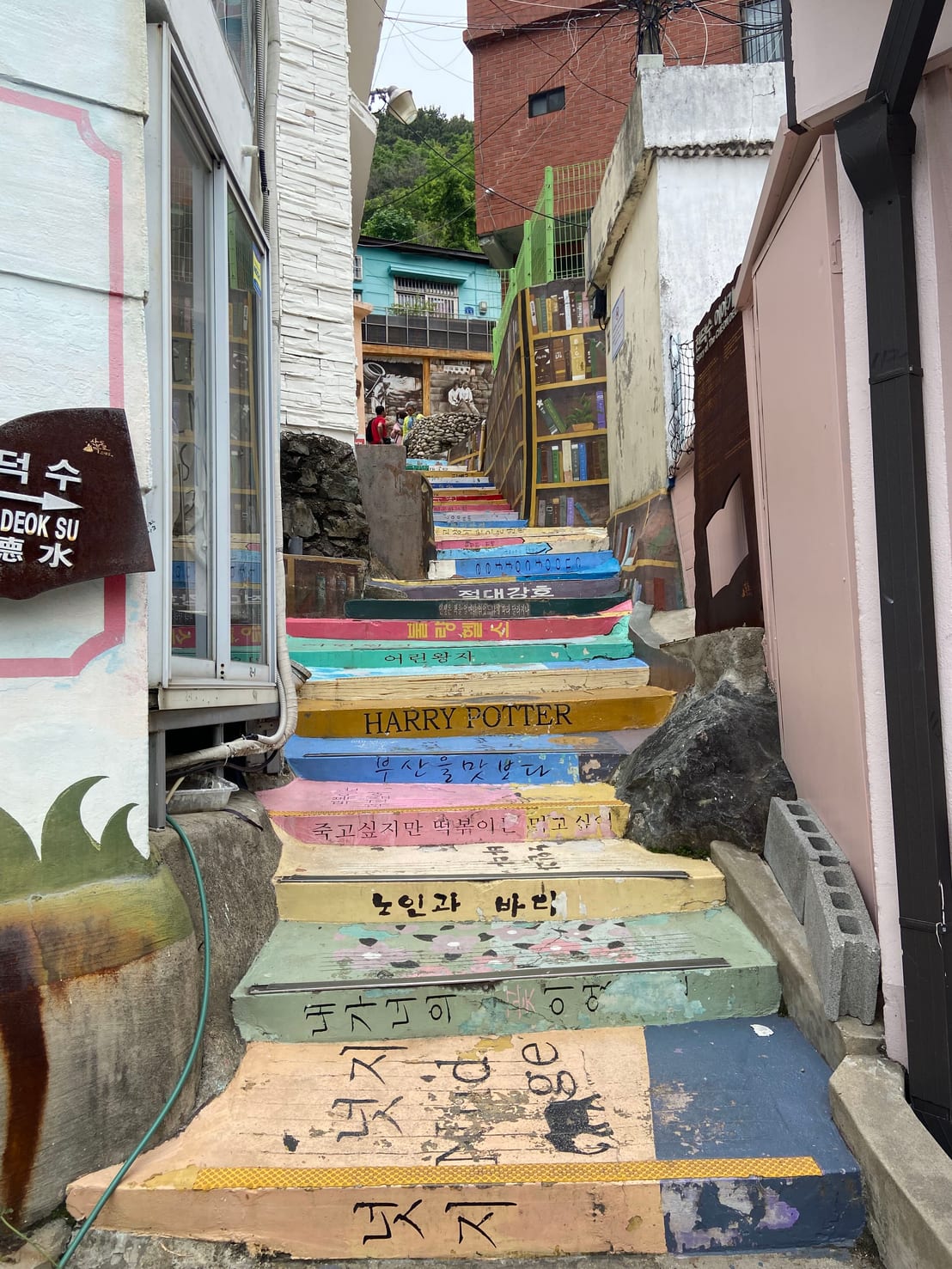 A staircase alley with steps painted to look like the spines of famous books, including Harry Potter and The Little Prince