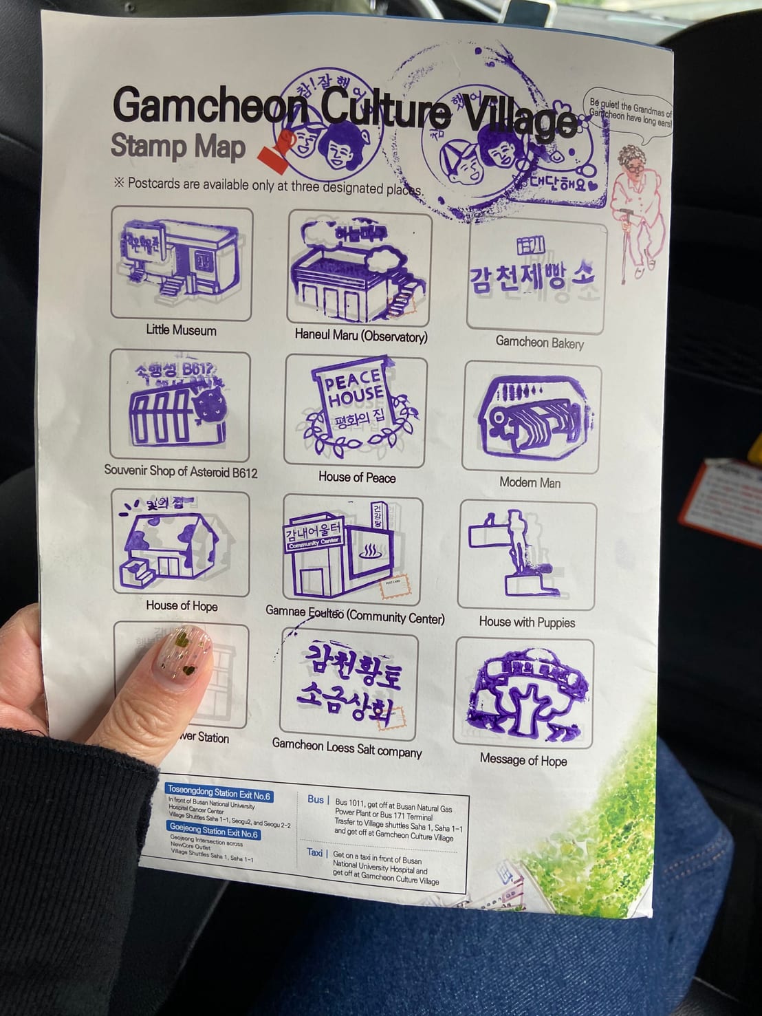 A held Gamcheon Culture Village stamp map, mostly filled in with purple ink stamps from Little Museum, Peace House, House of Hope, and more