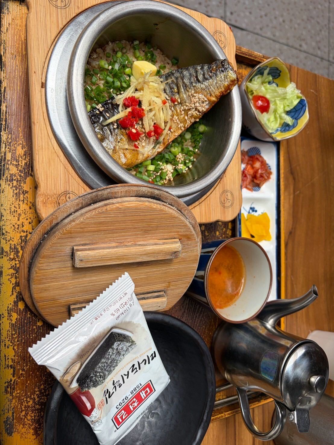 Mackerel pot rice at Damsot, served in a metal pot with pickled sides and barley tea