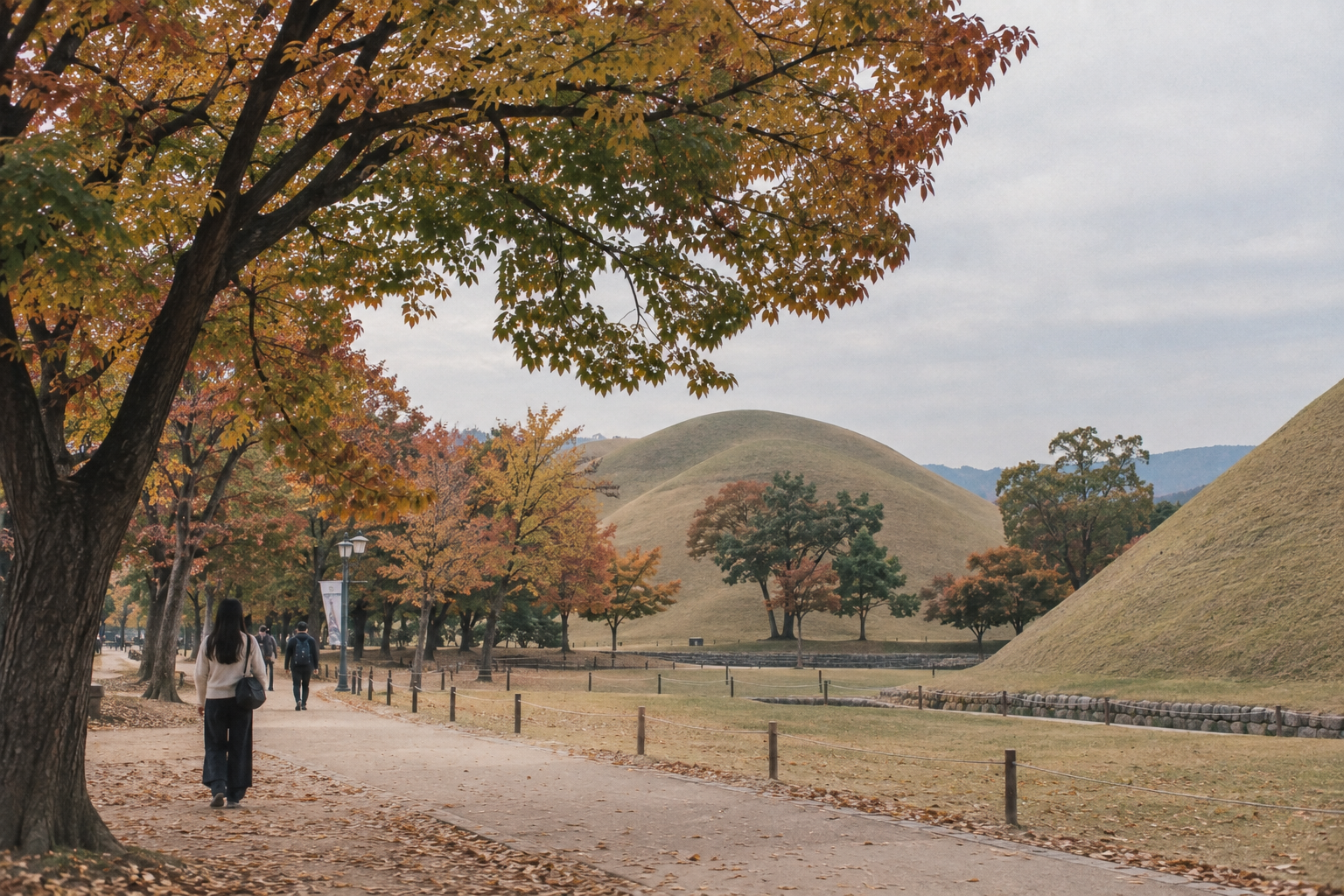 The grass-covered royal burial mounds of Daereungwon in Gyeongju surrounded by autumn-coloured trees