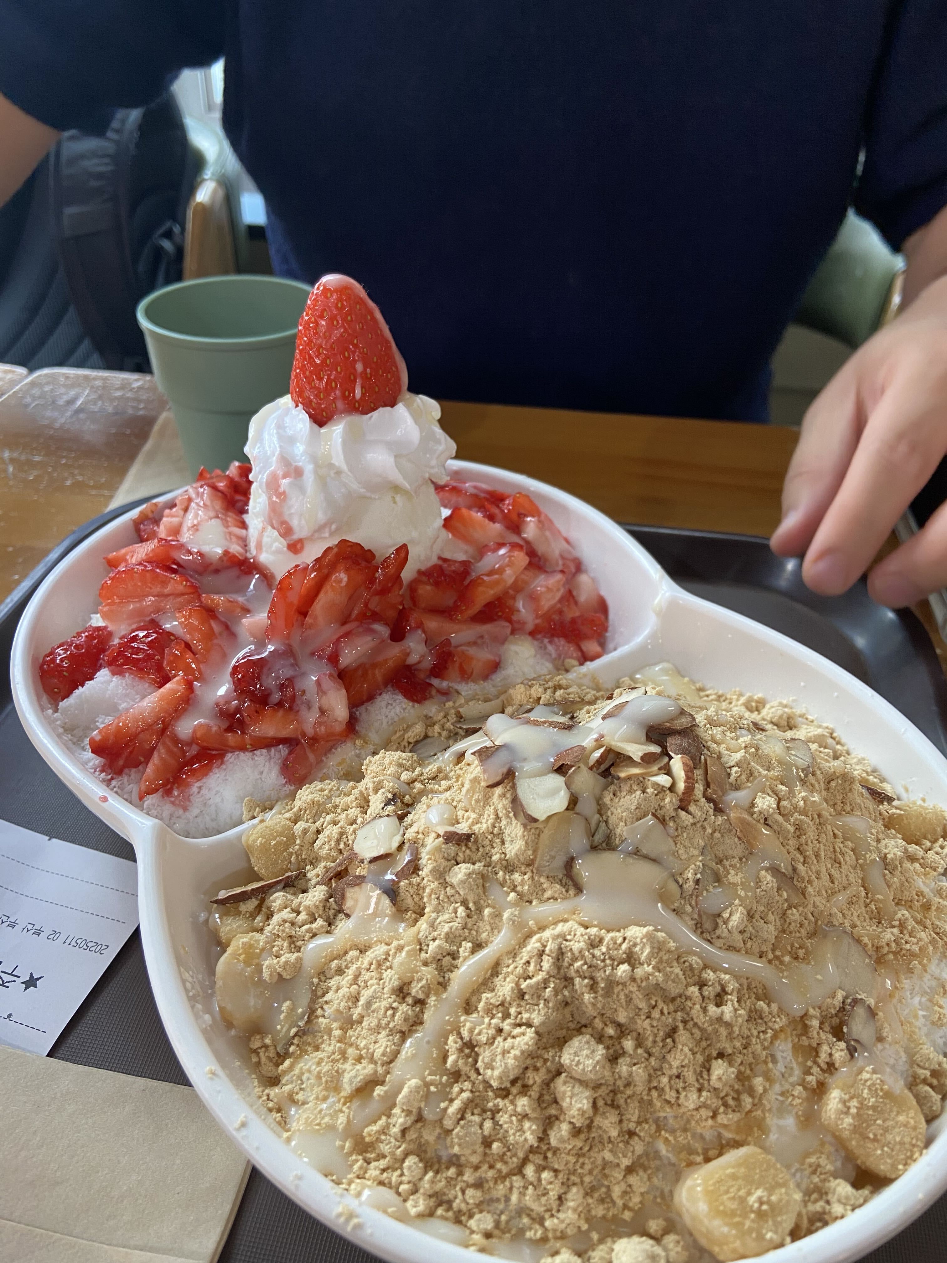 Korean bingsu shaved ice topped with strawberries, cream, injeolmi powder and almonds
