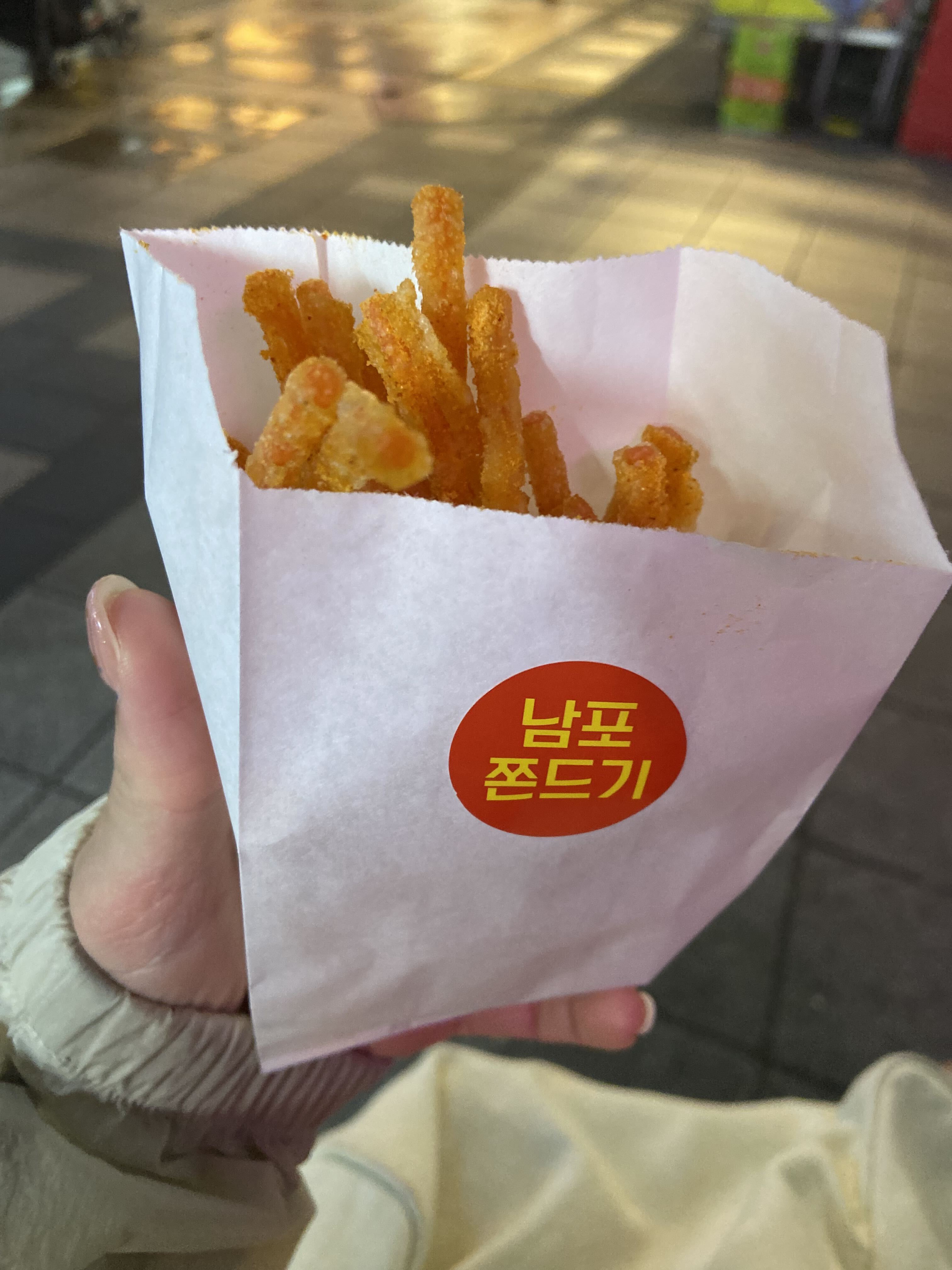 A paper cup filled with seasoned Korean jjondeugi snack sticks