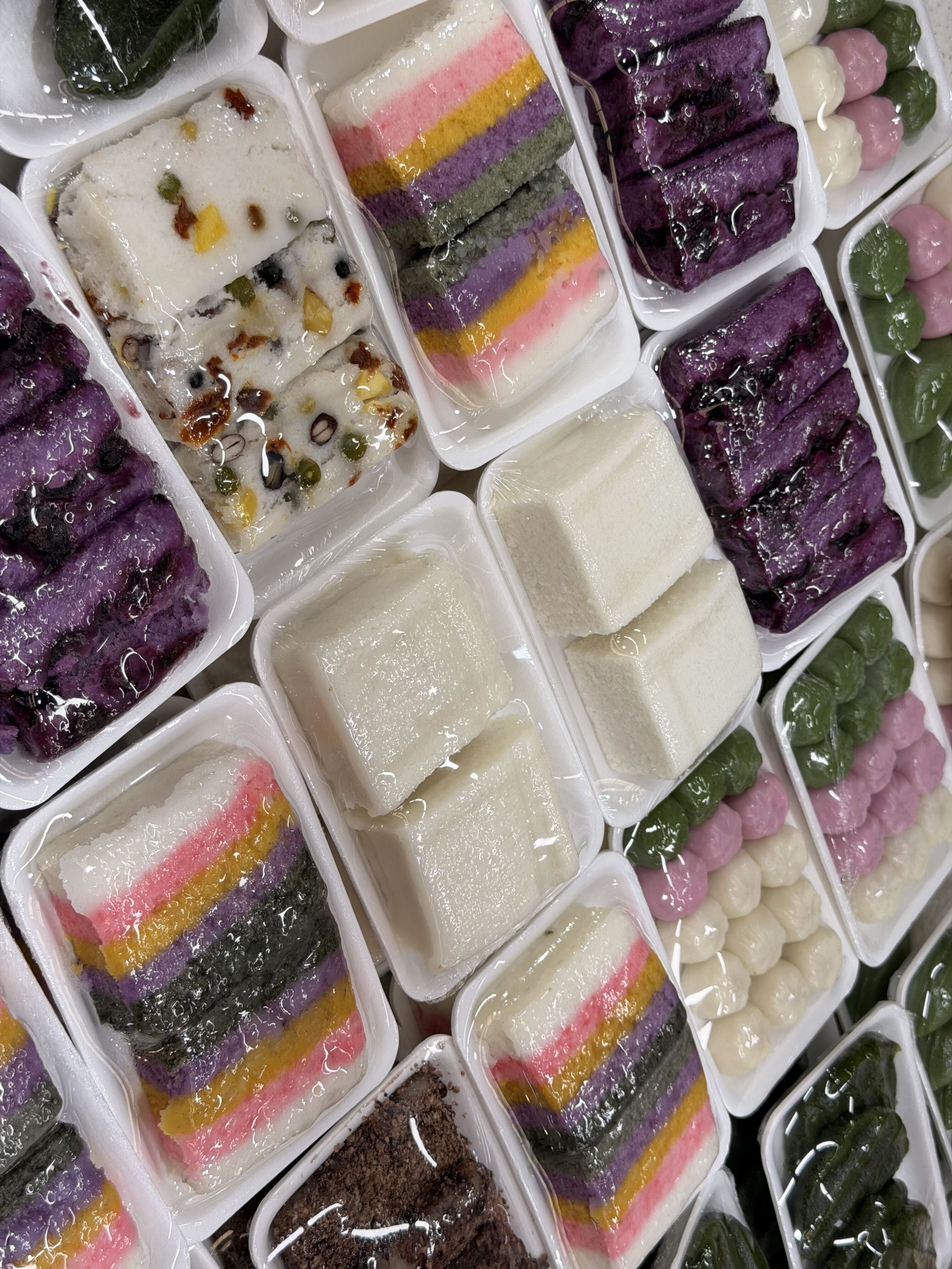 Colourful varieties of Korean tteok, or rice cakes, arranged at a market stall