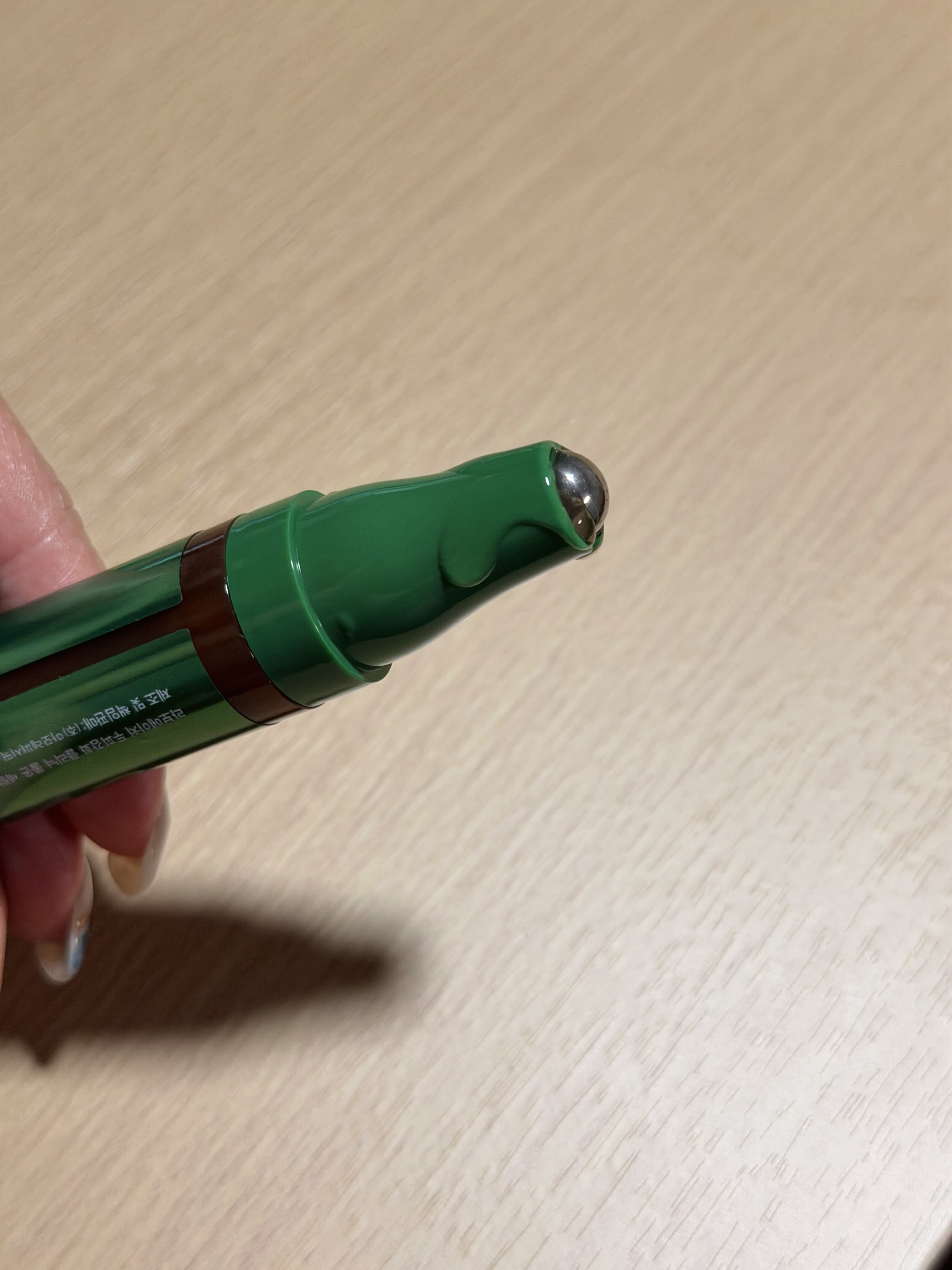 Close-up of the LABO·H roll-on serum's metal rollerball tip, with a second capped pen beside it