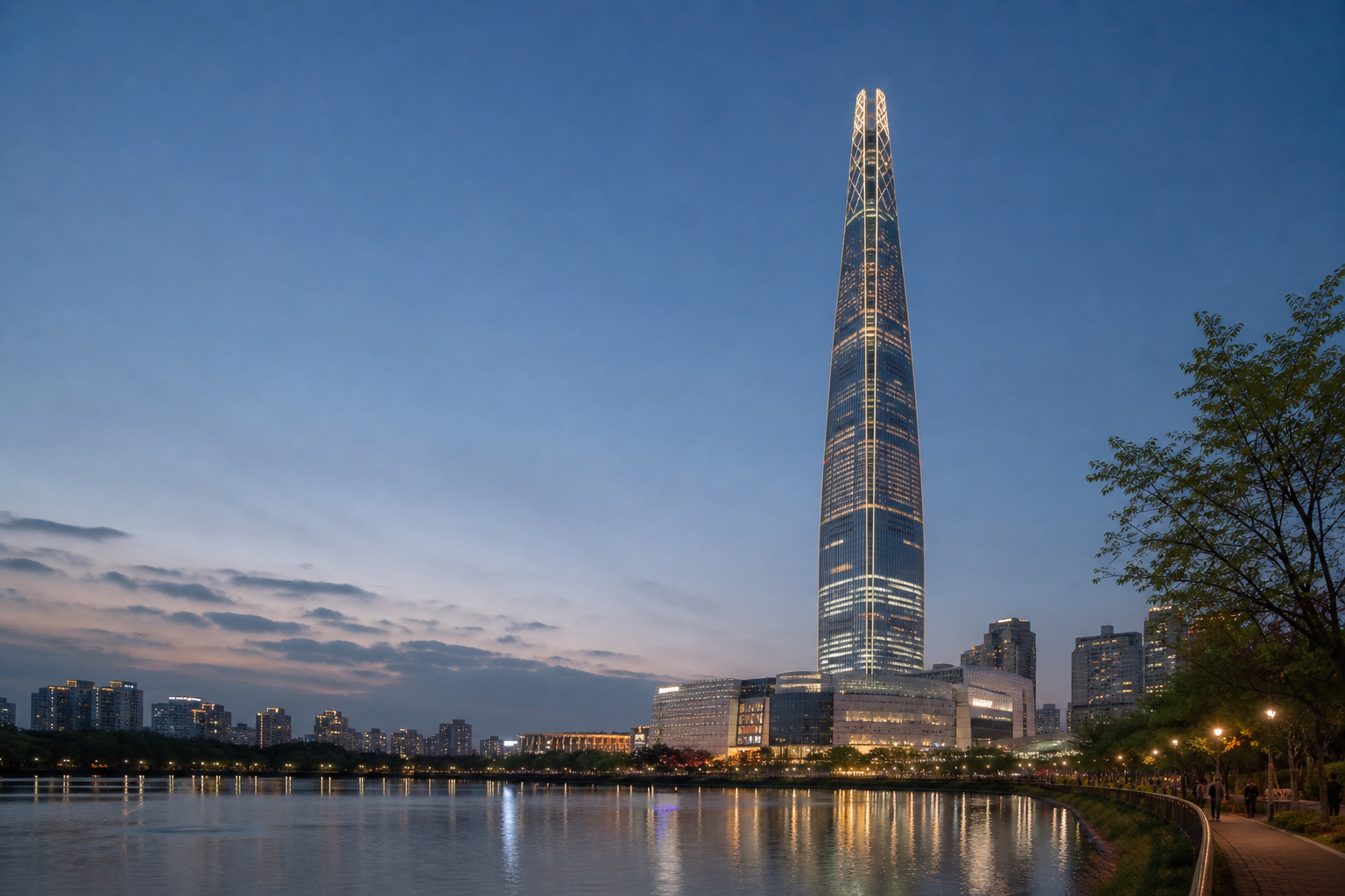Lotte World Tower rising over the Seokchon Lake waterfront at dusk