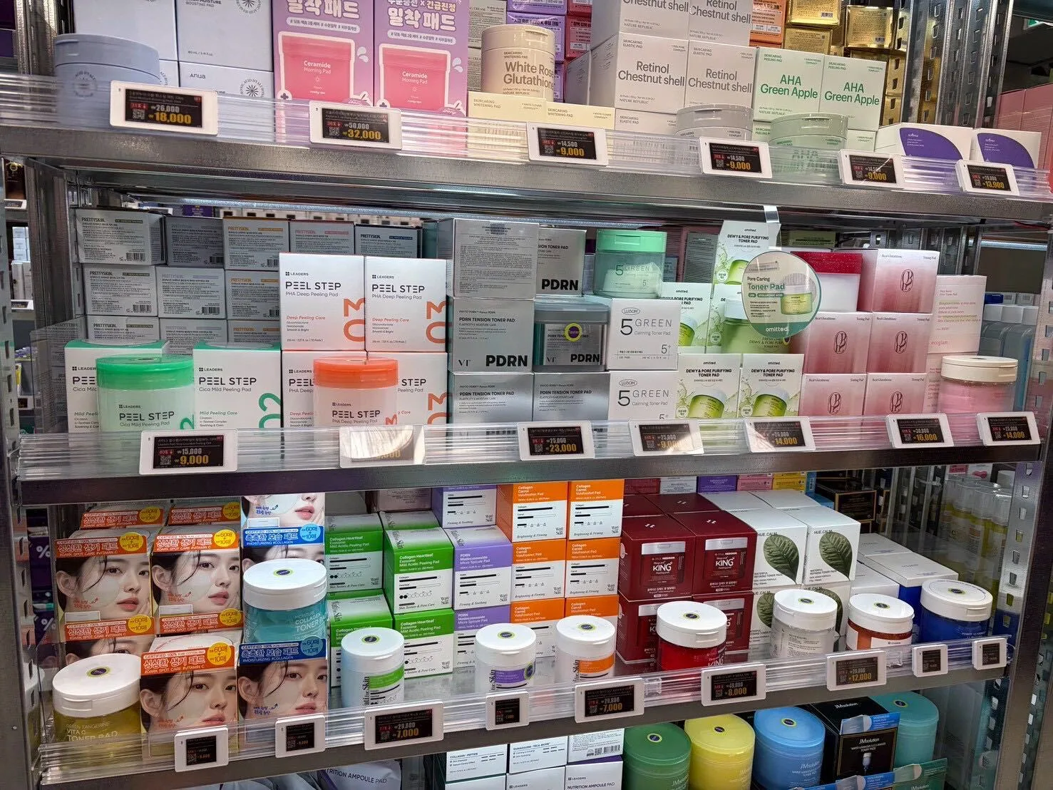 Shelves of toner pads and peeling pads at Off Beauty, including PDRN Tension Toner Pad and 5 Green Calming Toner Pad, each with discount price tags