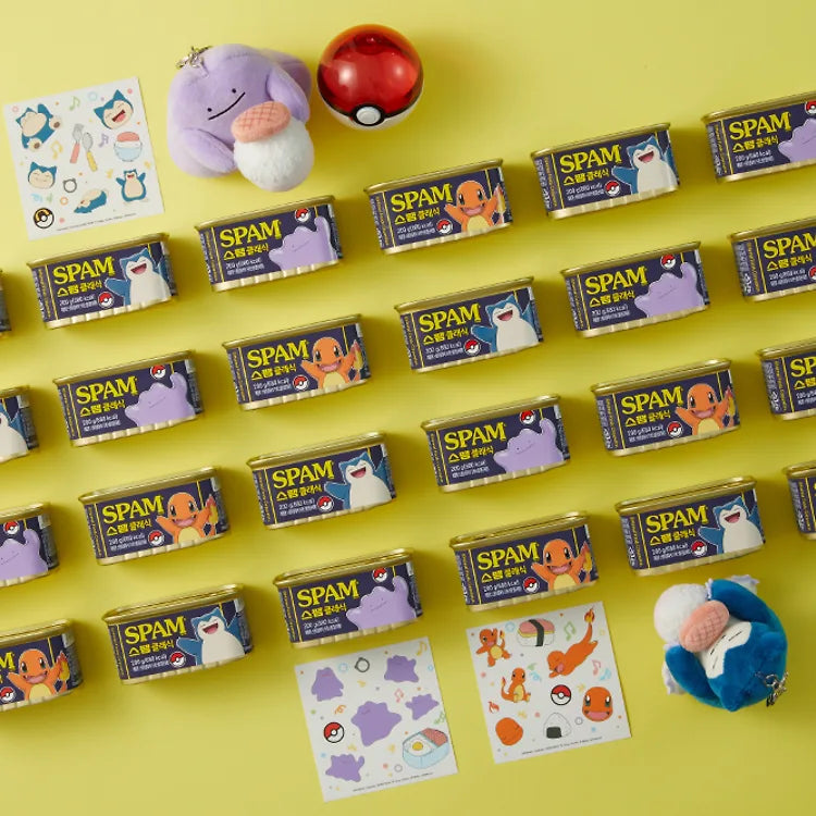 Rows of Pokémon SPAM Edition cans featuring Charmander, Snorlax, and Ditto, laid out next to the Snorlax and Ditto plush keychains and sheets of Pokémon stickers