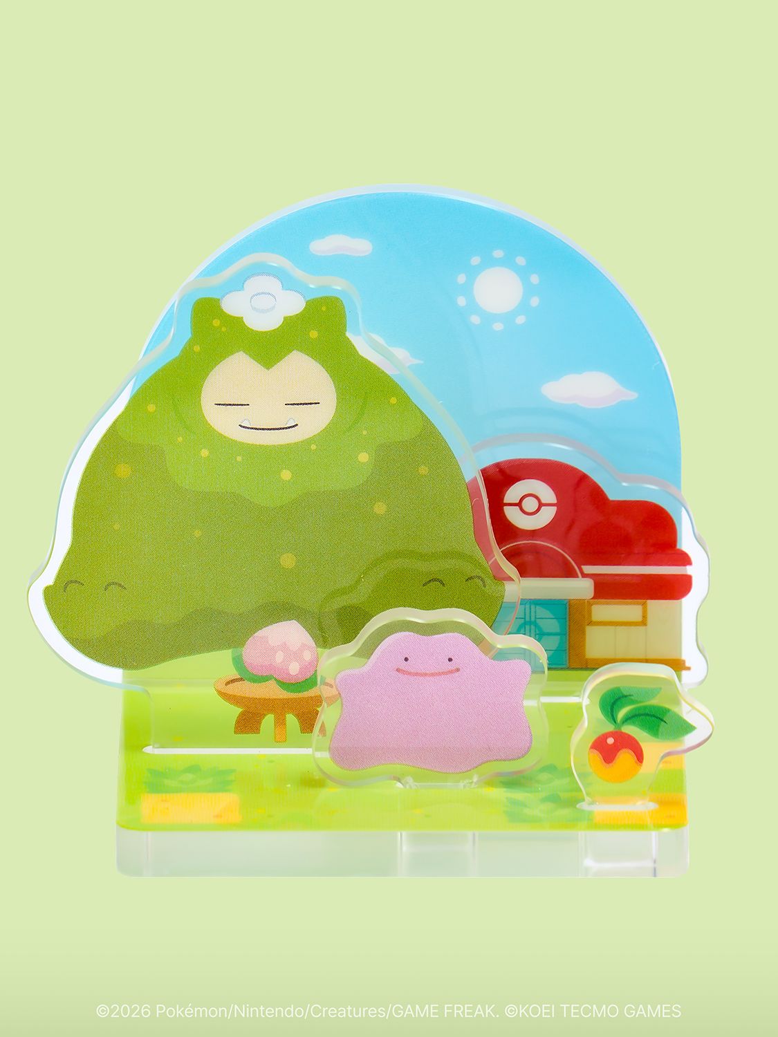 An acrylic diorama stand showing Professor Tangrowth, Ditto, and the Pokémon Center on a green hill