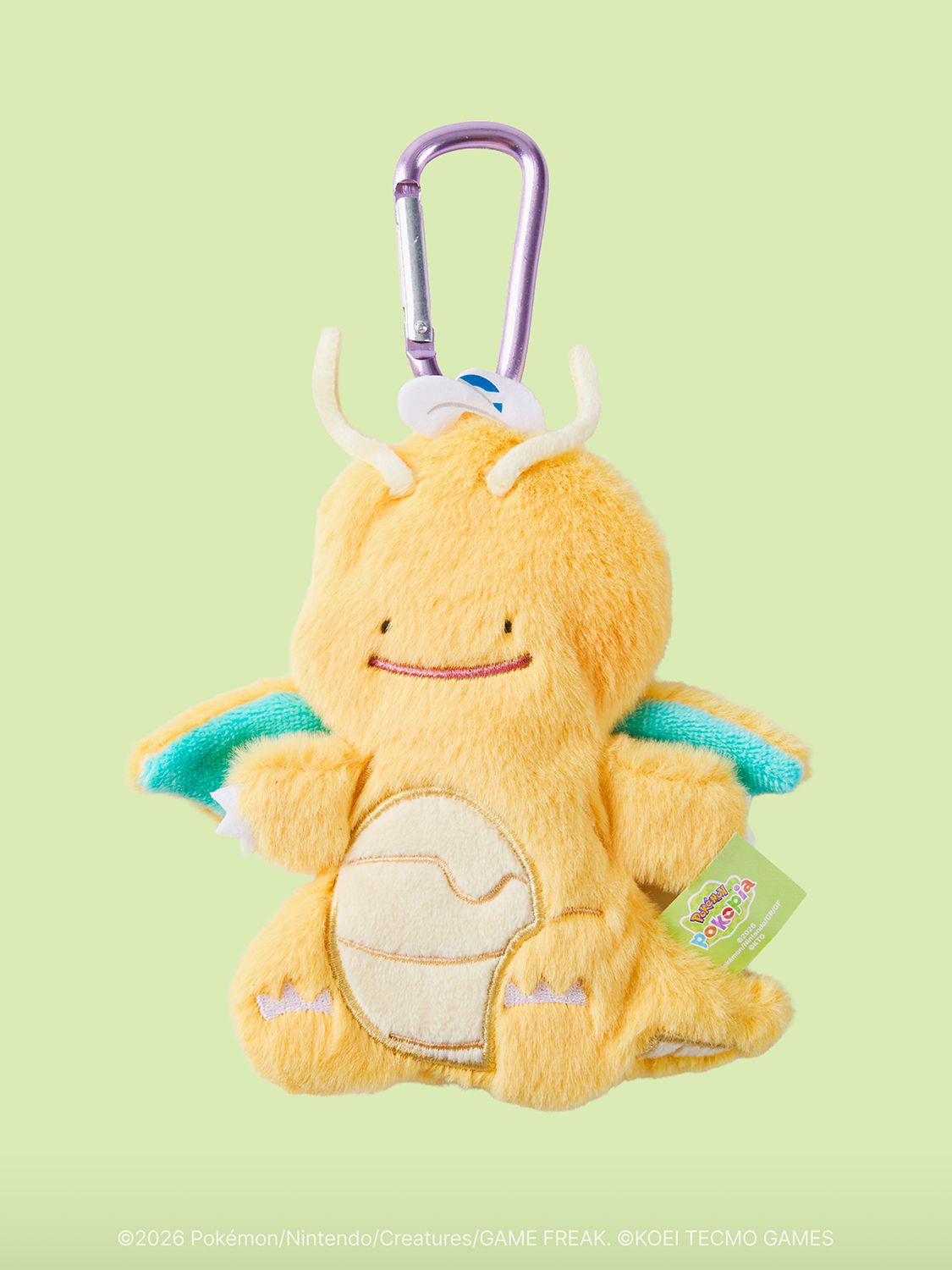 An orange plush keyring of Ditto transformed into Dragonite, with Ditto's dot-eyed face