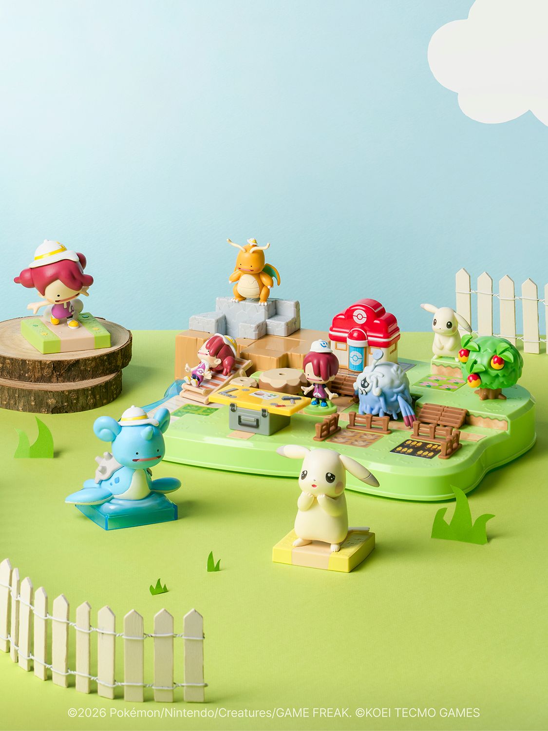 Small Pokopia figures of Ditto forms, Pale Pikachu and human characters arranged on a grassy playset diorama