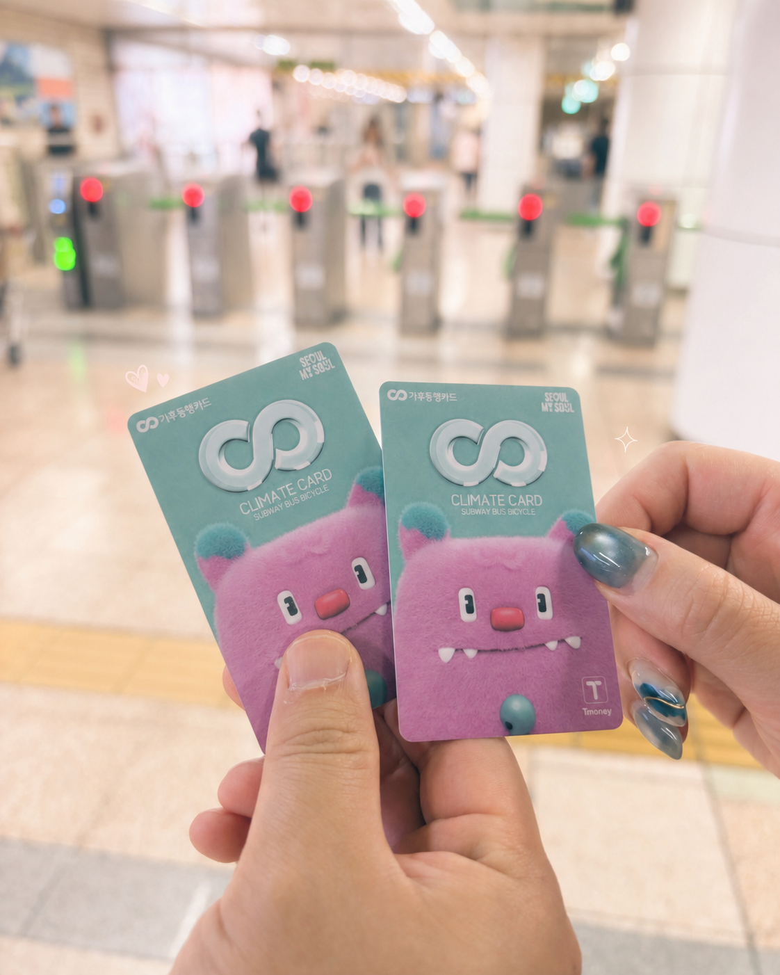 Holding two Climate Card transit cards up at a Seoul subway gate