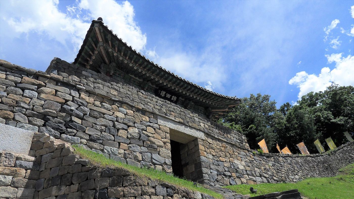 The stone walls and gate pavilion of Gongsanseong Fortress in Gongju under a blue summer sky