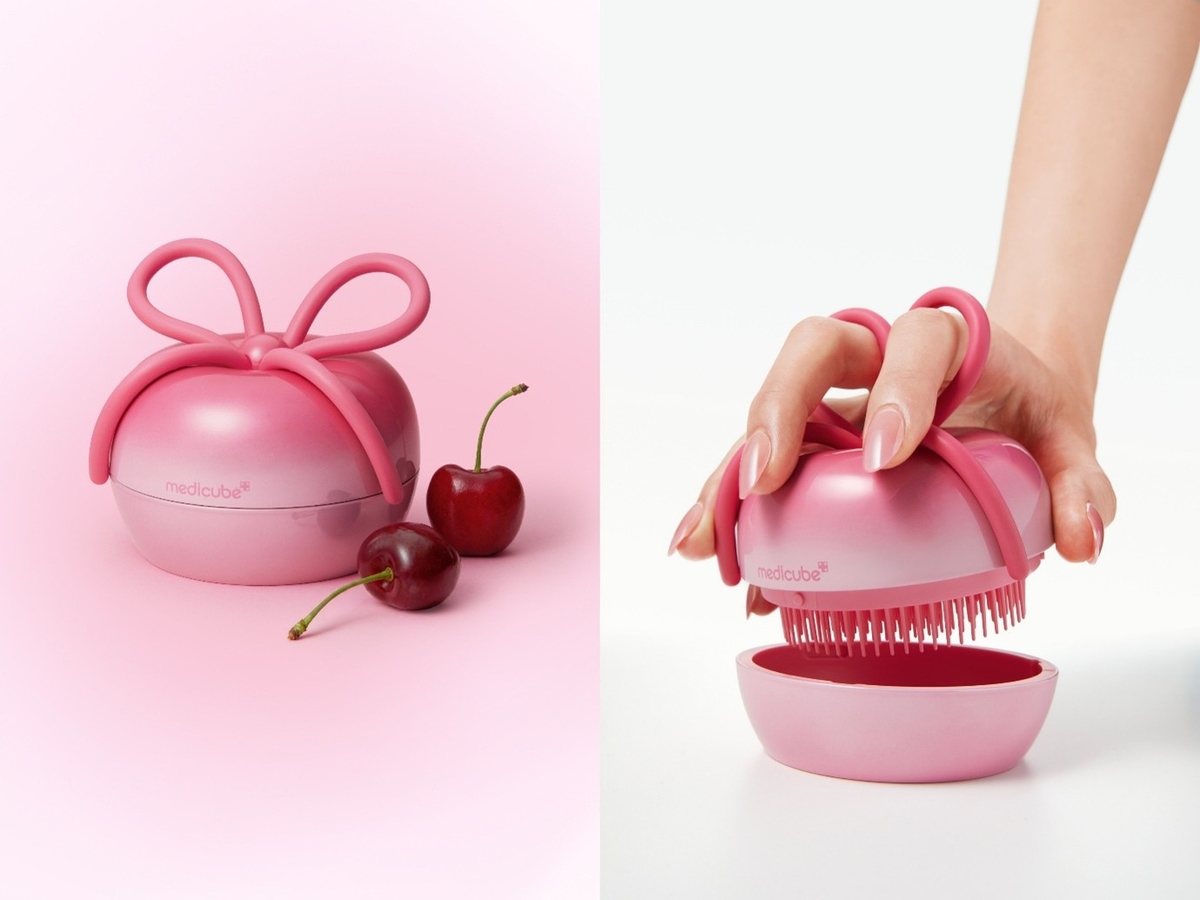 The FOREVER:CHERRY x Medicube hair brush shown closed in its cherry-shaped case with a ribbon bow handle, next to real cherries, and open in-hand showing the four-layer bristle head